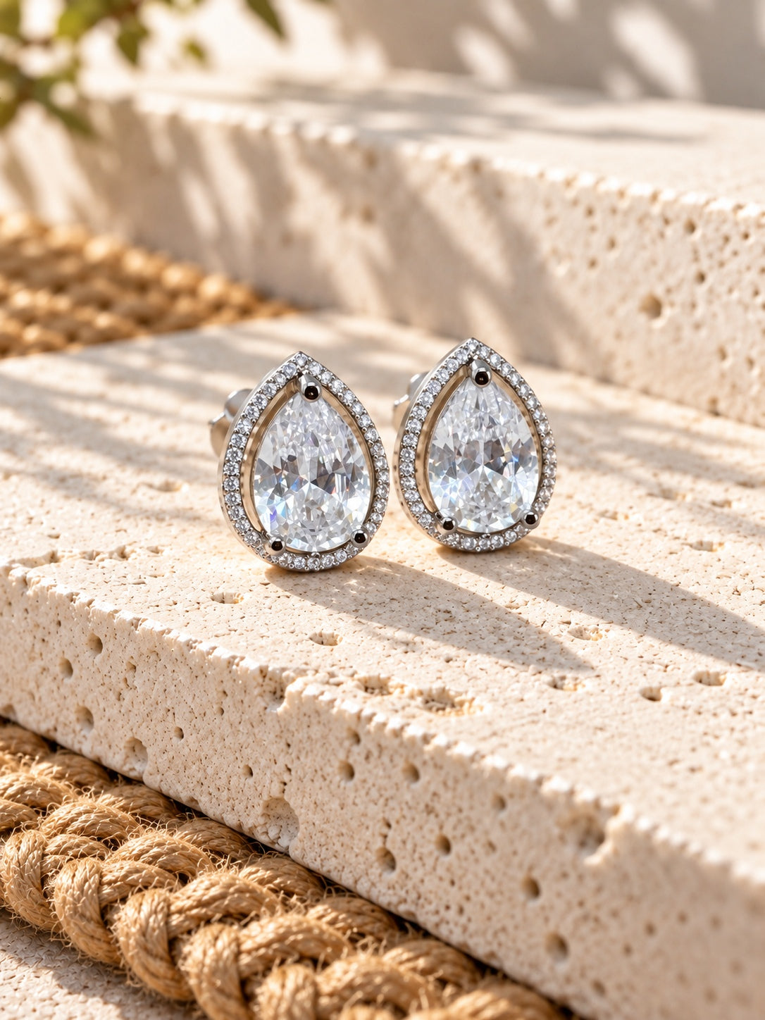 Niska AD Stone Silver Replica pear stud earrings on white travertine, view 2