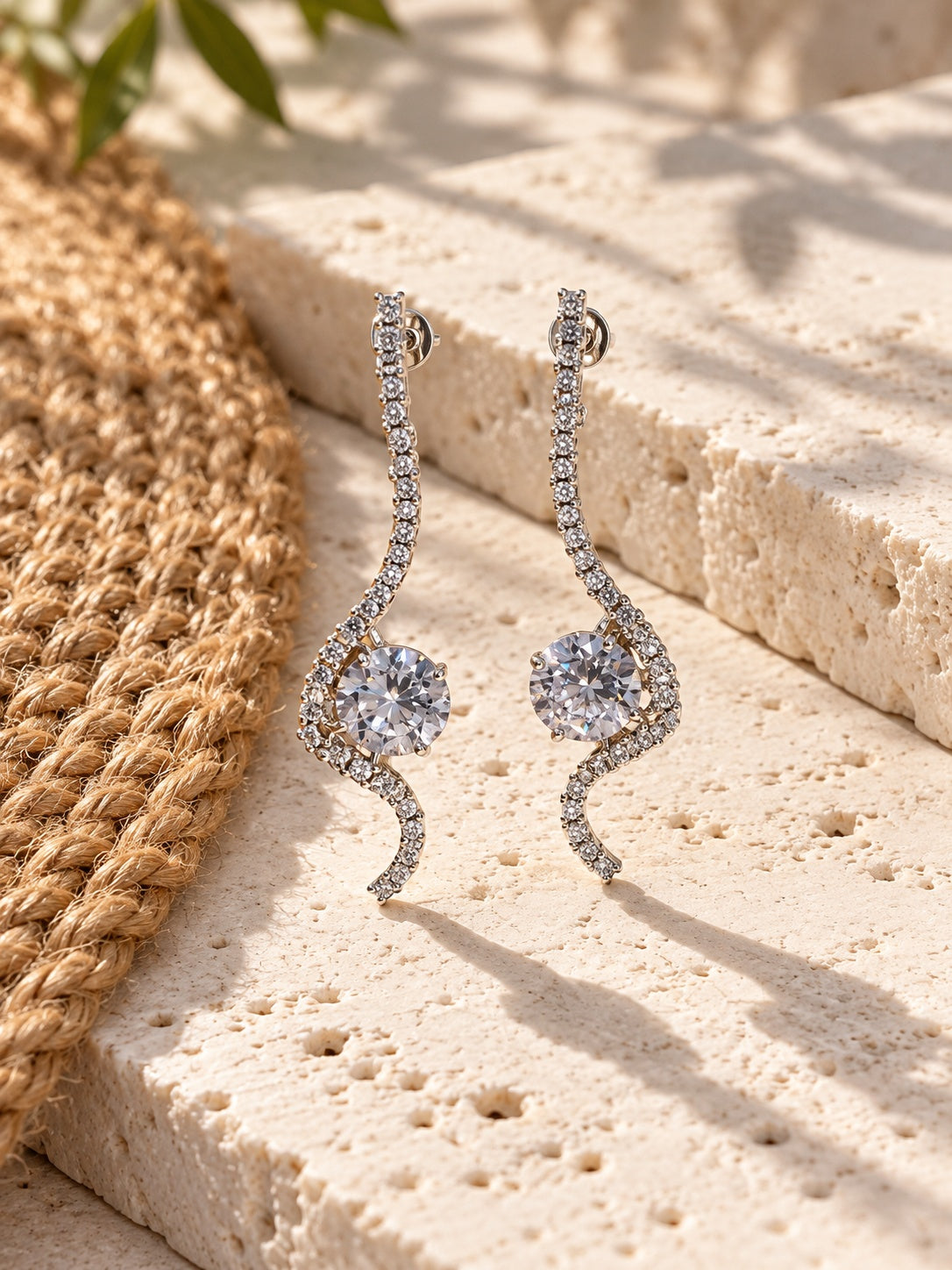 Niska AD Stone Silver Replica curved drop earrings on white travertine
