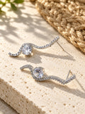 Niska AD Stone Silver Replica curved drop earrings on white travertine