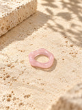 Blush pink sculpted replica ring on sunlit ivory travertine