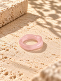 Blush pink sculpted replica ring on sunlit ivory travertine