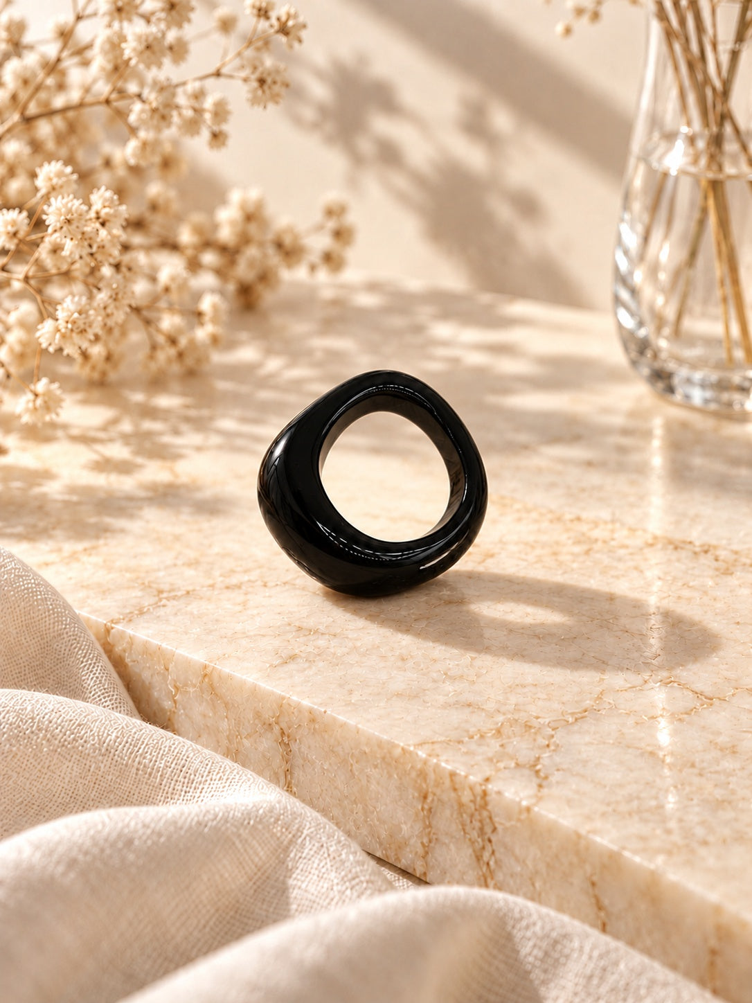 Niska glossy black statement replica ring on cream marble