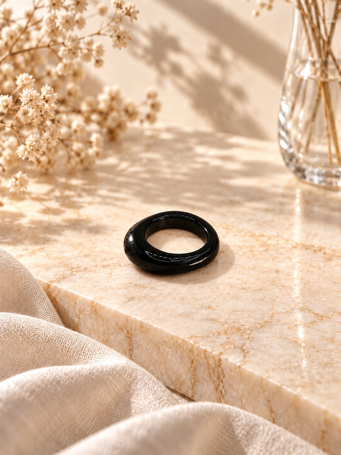 Niska glossy black statement replica ring on cream marble