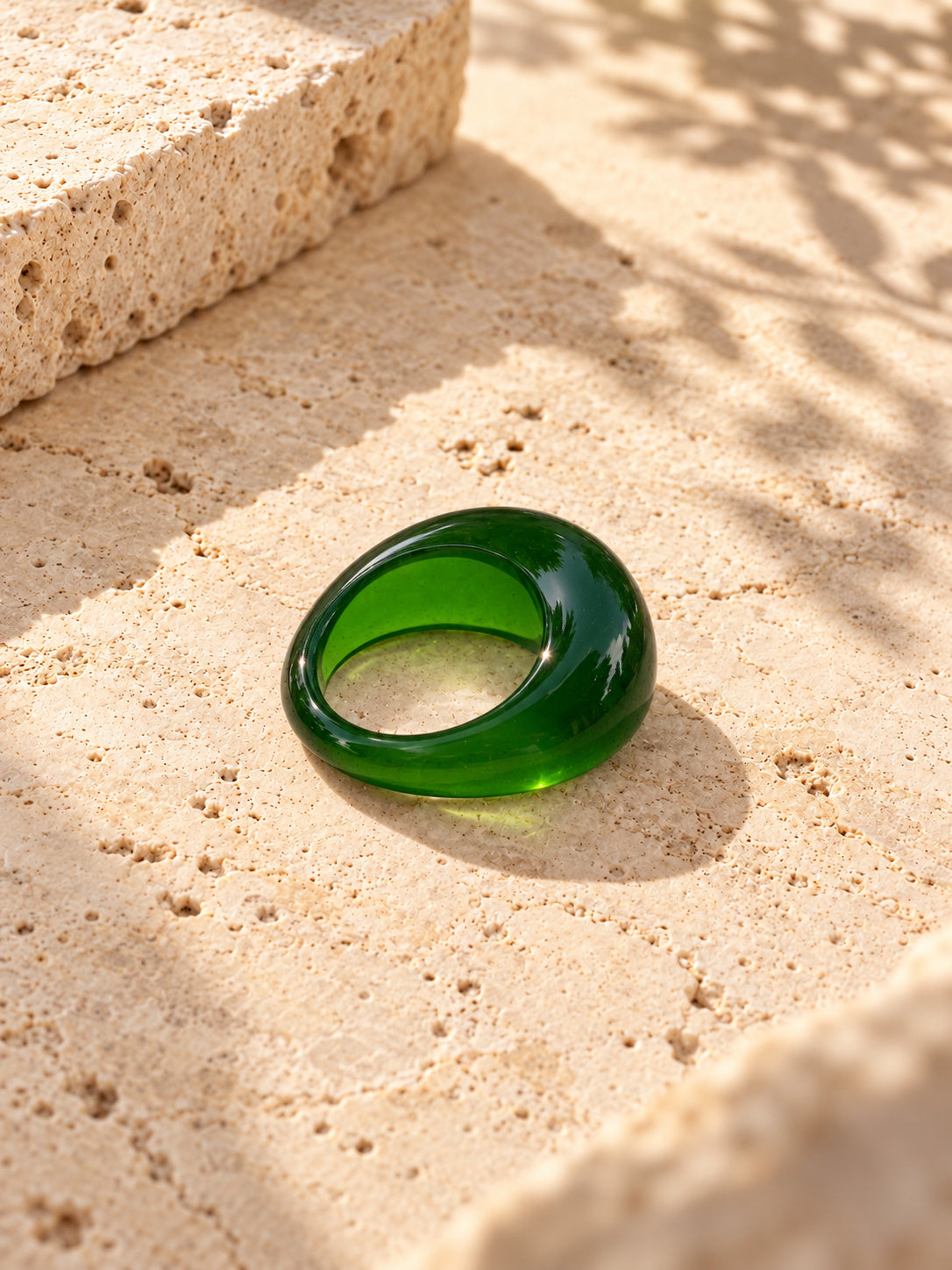 Niska green dome ring worn on a model's hand, close-up with lips
