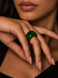 Niska green dome ring worn on a model's hand, close-up with lips