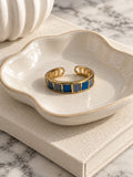 Niska blue and grey mosaic adjustable gold-tone ring in ivory ceramic dish