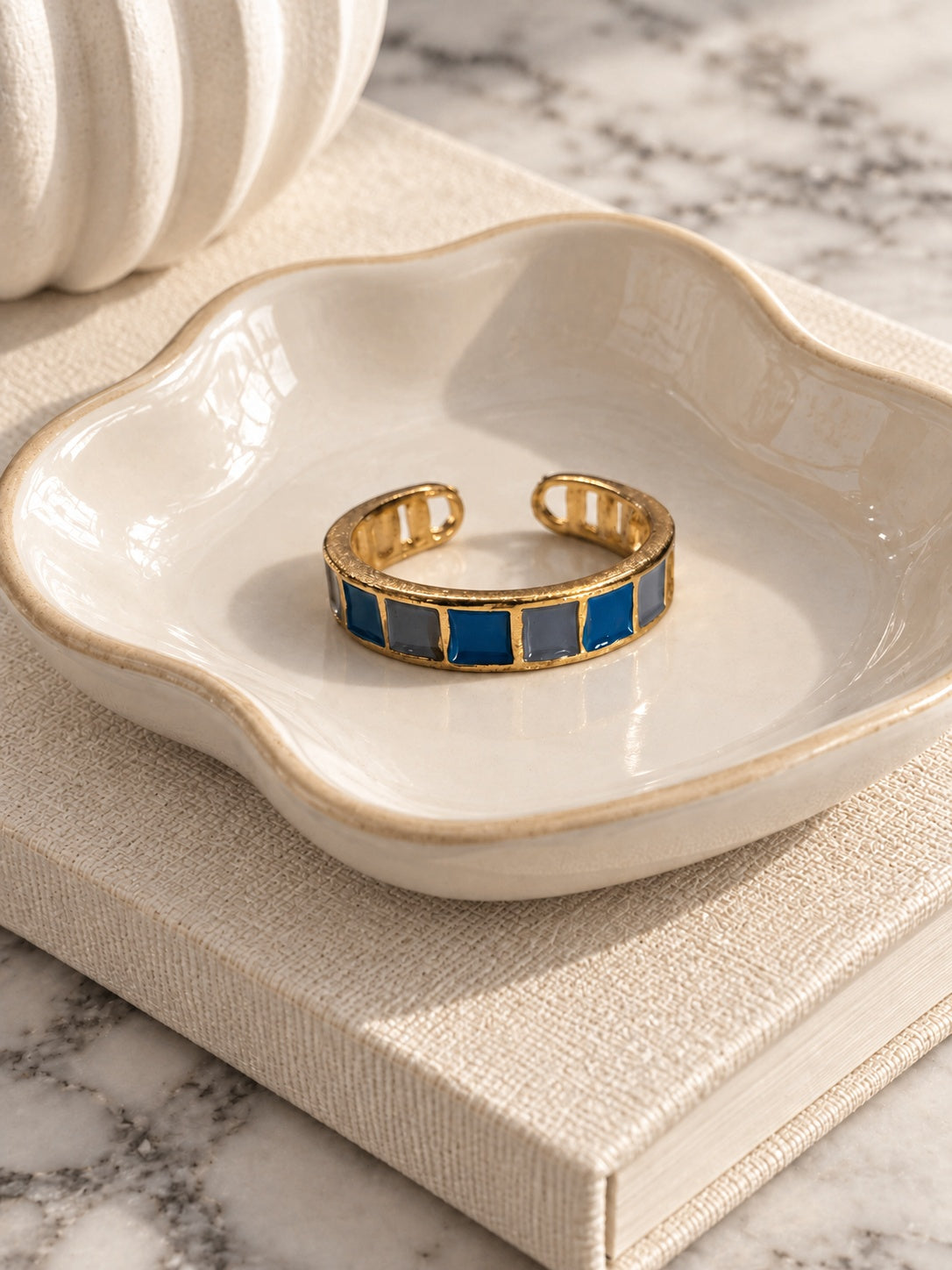 Niska blue and grey mosaic adjustable gold-tone ring in ivory ceramic dish