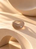 Taupe chunky resin replica ring on textured stone, view 3