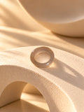 Taupe chunky resin replica ring on textured stone, view 4
