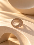 Taupe chunky resin replica ring on textured stone, view 5
