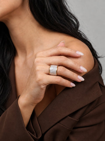 Niska pearl-white gold-tone adjustable wide band ring worn with a brown outfit