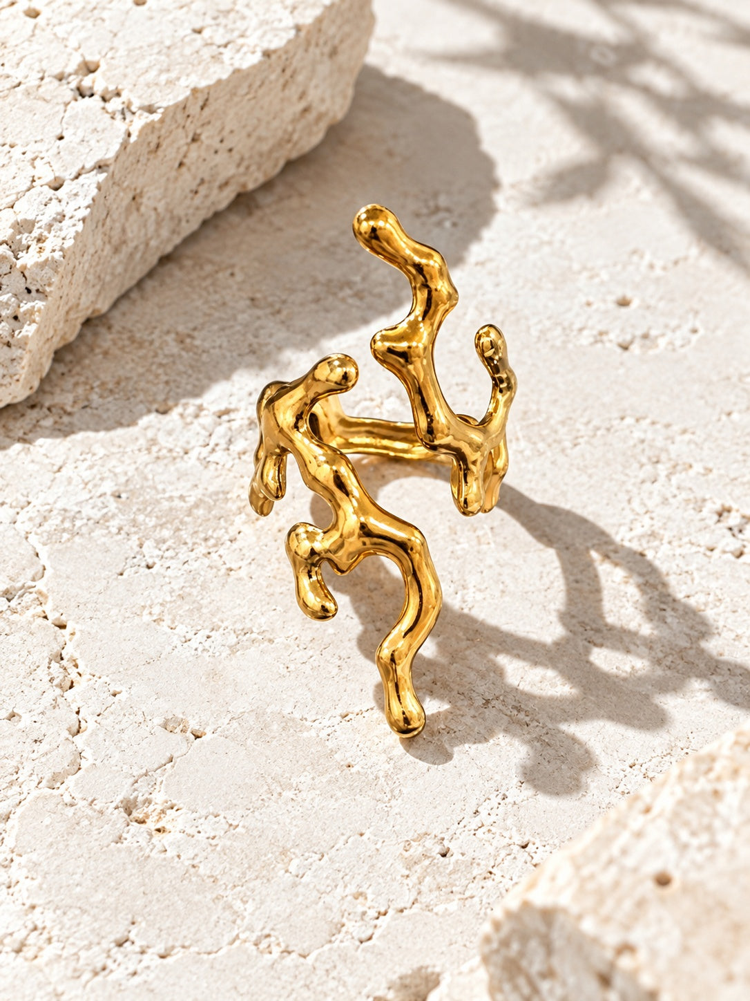 Niska sculptural gold ring on stone surface