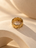 Niska gold-tone geometric statement ring on a cream sculptural platform, view 1