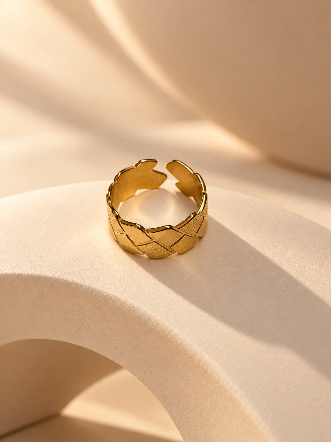 Niska gold-tone geometric statement ring on a cream sculptural platform, view 2