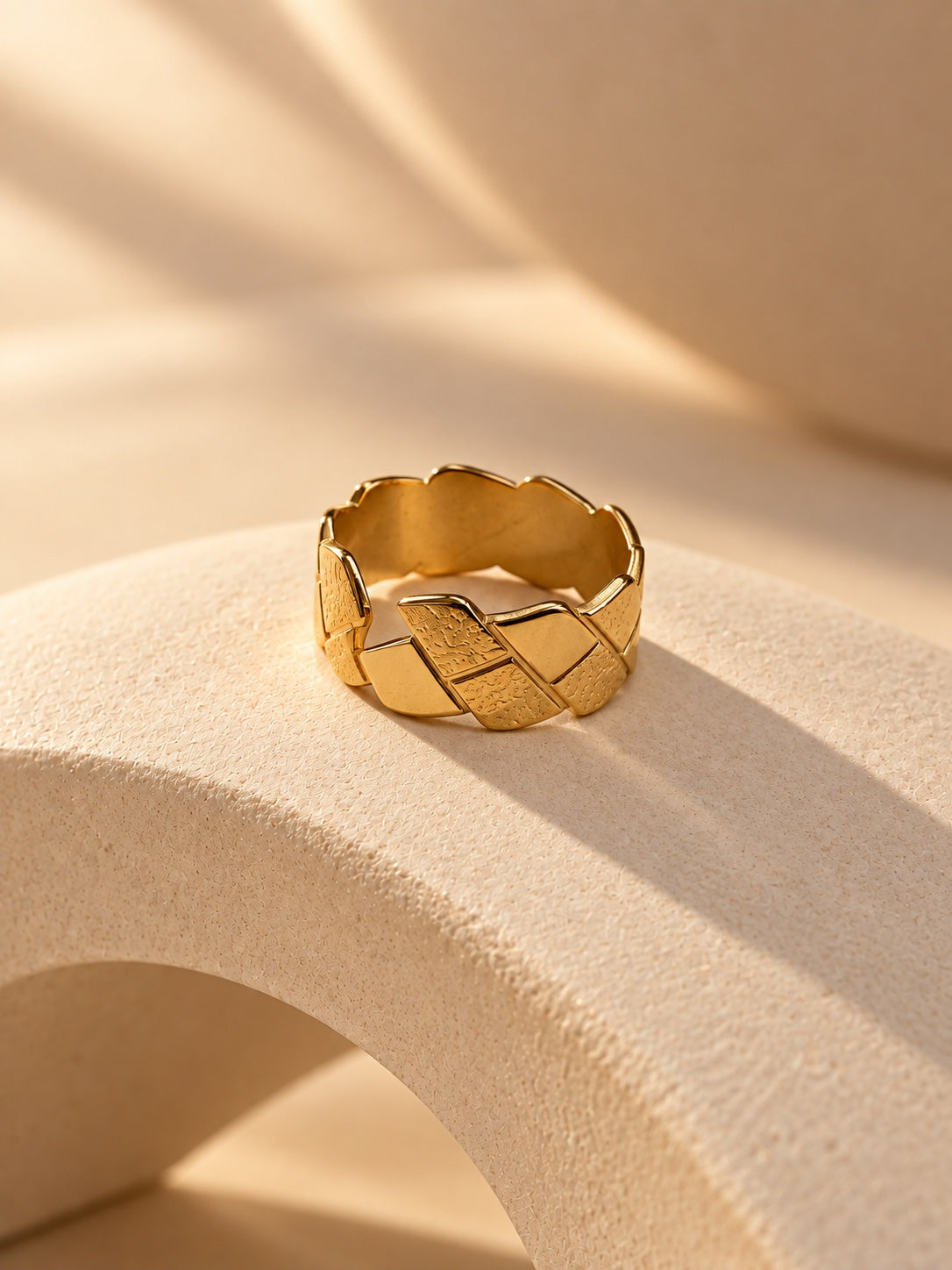 Niska gold-tone geometric statement ring on a cream sculptural platform, view 4