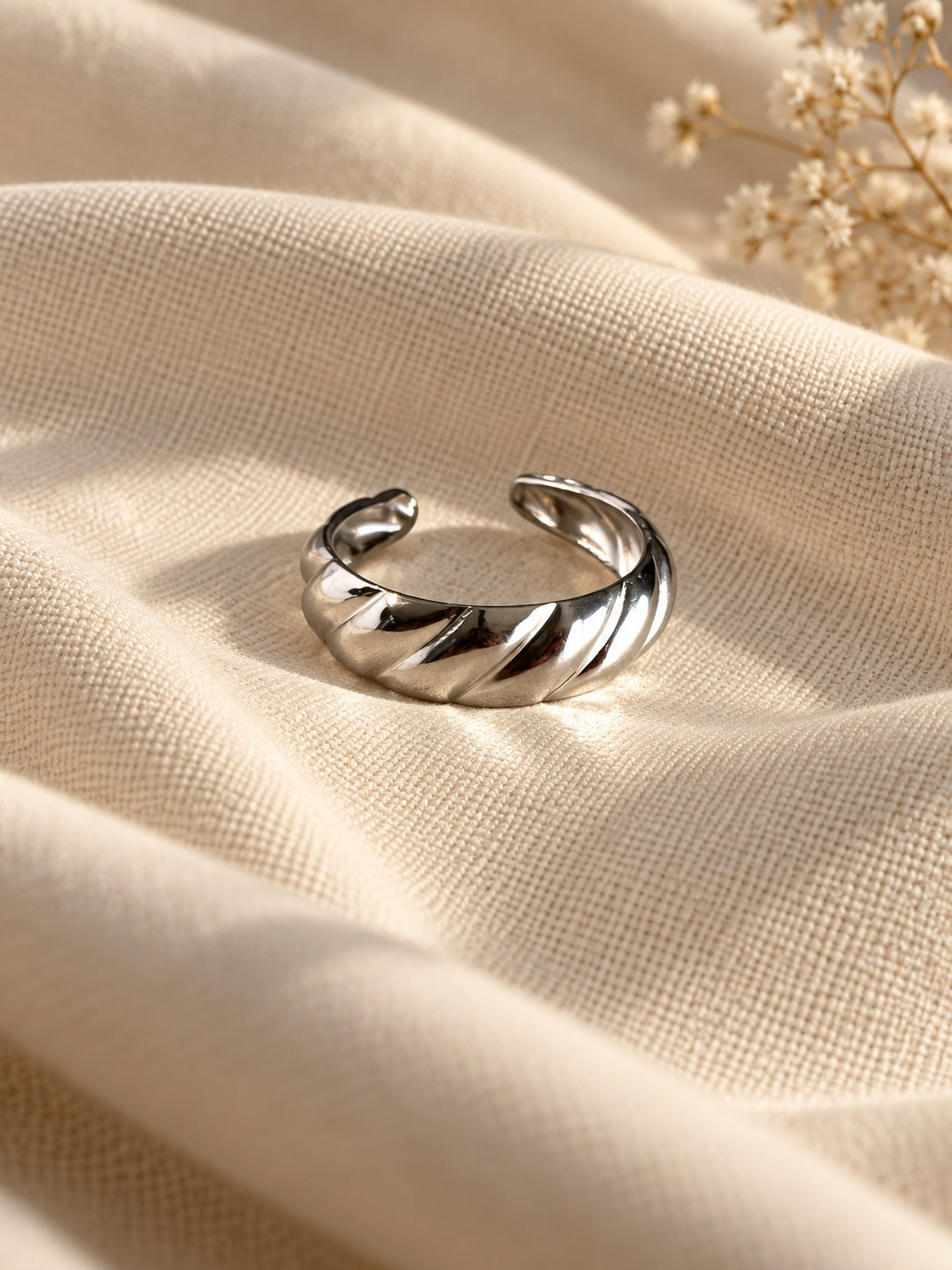 Niska silver-tone twisted band replica ring worn on a model, close-up