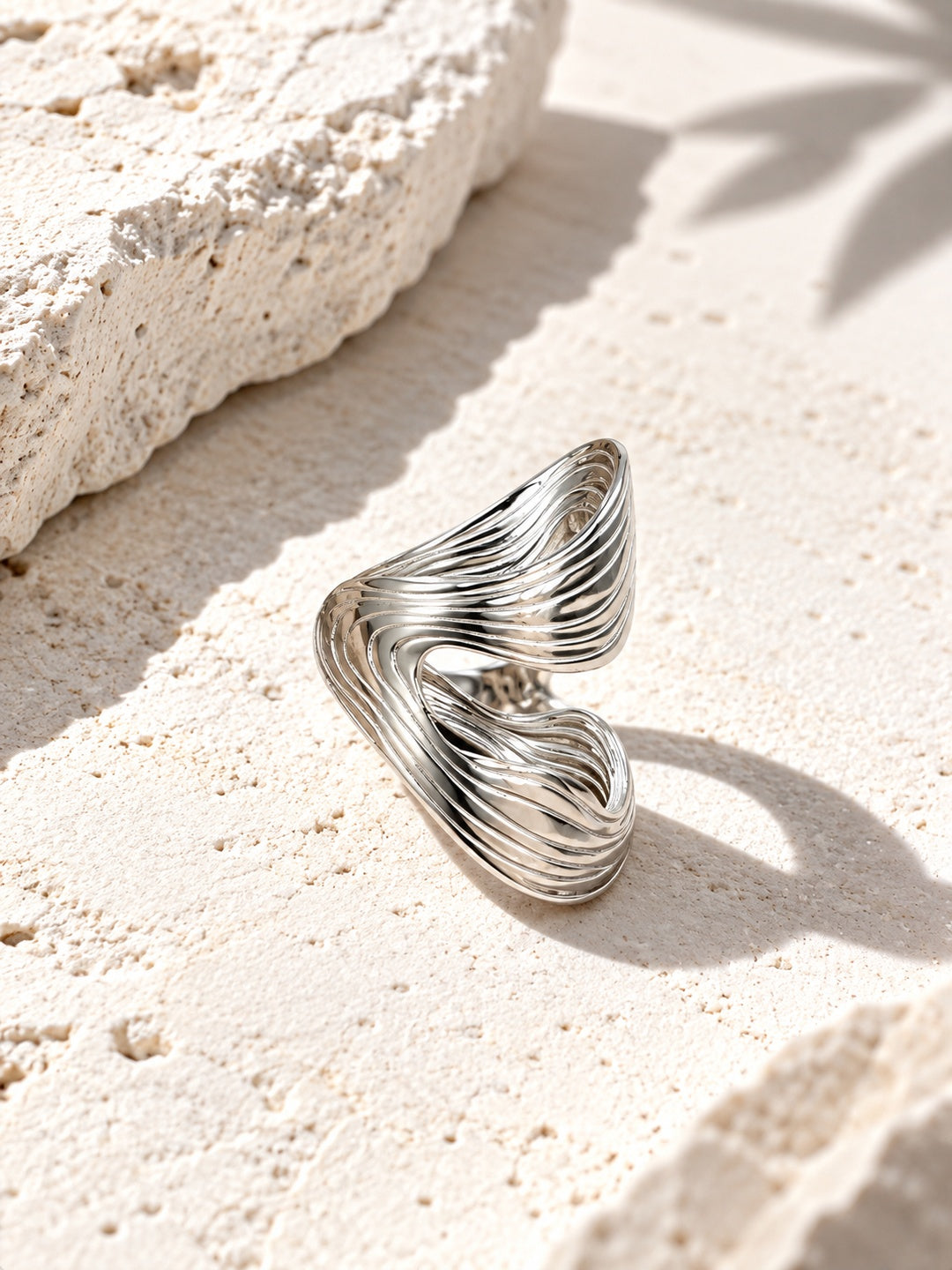 Niska sculptural ring on textured stone surface