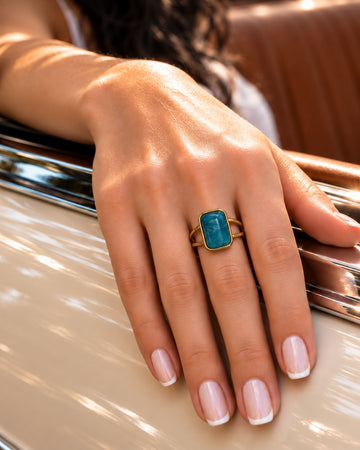 Niska blue-green statement ring worn on model hand close-up