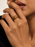 Niska brown and gold-tone replica band ring worn on a model's hand
