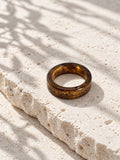 Brown and gold-tone replica band ring on ivory travertine, view 1