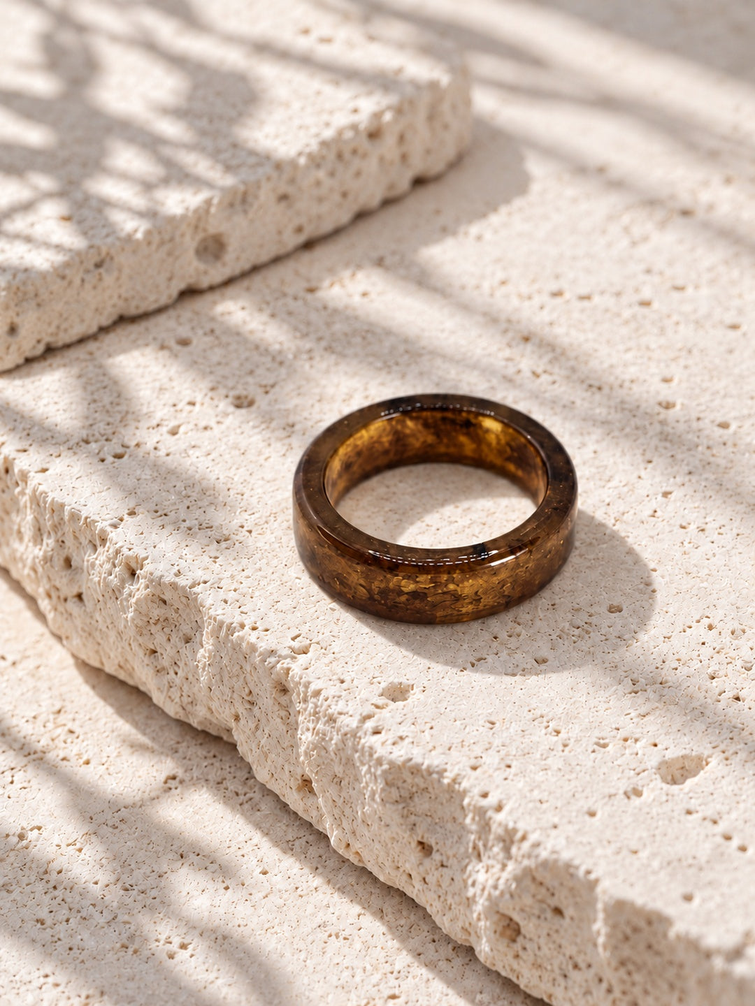 Brown and gold-tone replica band ring on ivory travertine, view 2