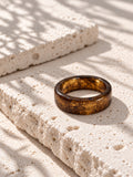 Brown and gold-tone replica band ring on ivory travertine, view 3