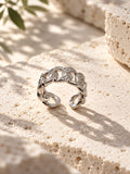Niska silver-tone stone-studded chain link replica ring on travertine