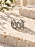 Niska silver-tone stone-studded chain link replica ring on travertine