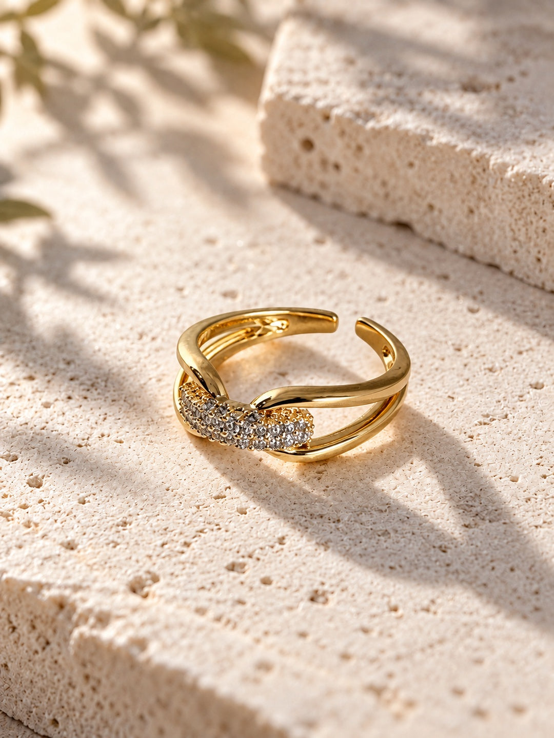 Niska gold-tone AD Stone split-band ring on travertine