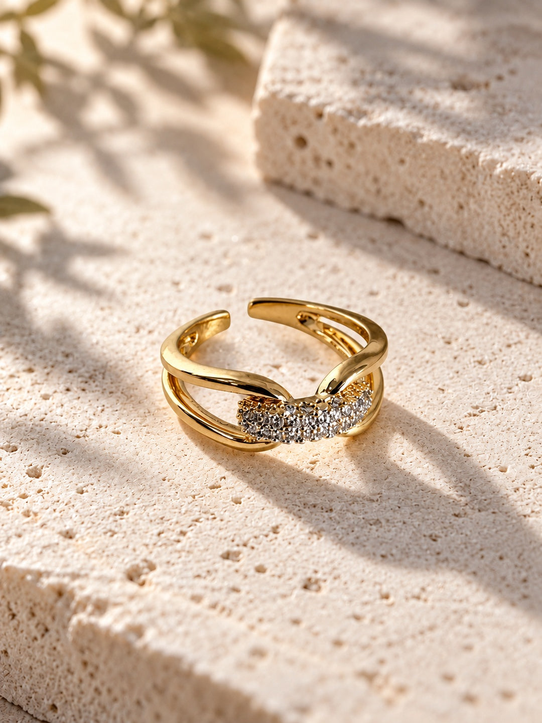 Niska gold-tone AD Stone split-band ring on travertine