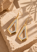 Angled still life of geometric gold and silver earrings