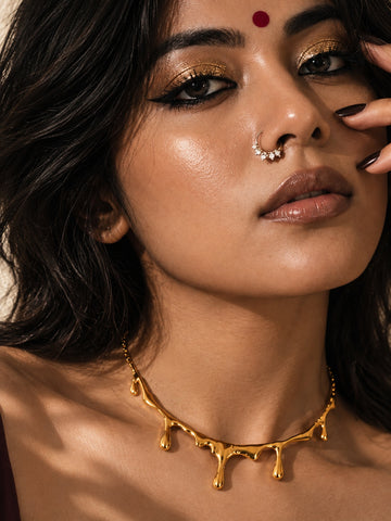 Model wearing Niska molten gold-tone drip statement necklace